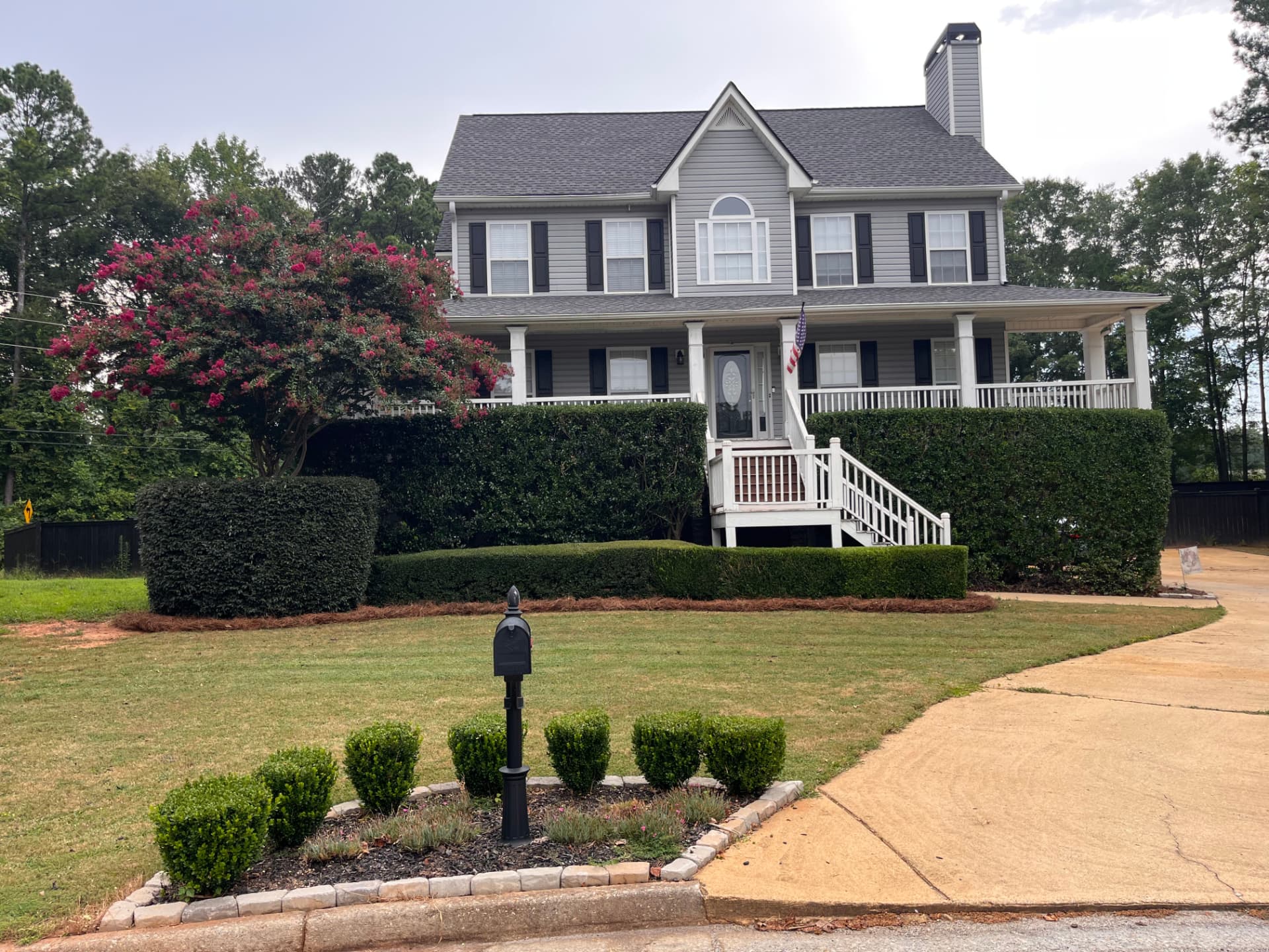 Front yard with neatly trimmed hedges, fresh mulch and stone edging